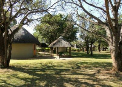 The huts in Malelane Camp look out on to a wide lawn with lots of trees